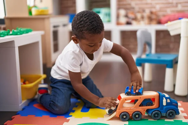 유치원 바닥에 자동차와 장난감을 가지고 아프리카 미국인 — 스톡 사진