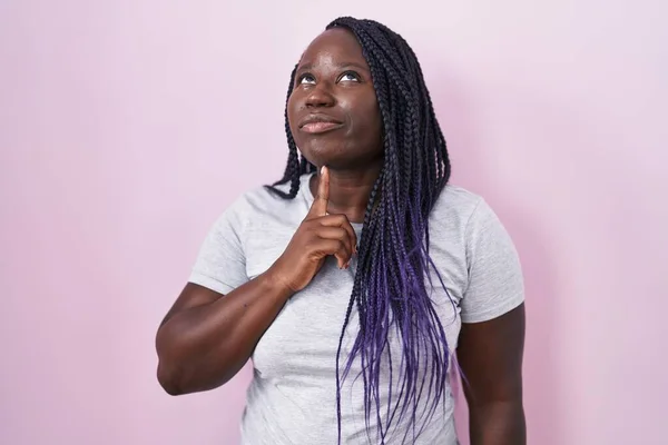 Молодая Африканская Женщина Стоящая Розовом Фоне Думающая Сомнении Пальцем Подбородке — стоковое фото