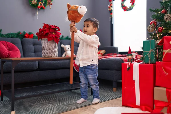 Bedårande Hispanic Barn Som Håller Häst Leksak Står Vid Julgran — Stockfoto