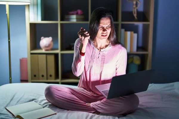 Young Hispanic Woman Using Computer Laptop Bed Angry Mad Raising —  Fotos de Stock