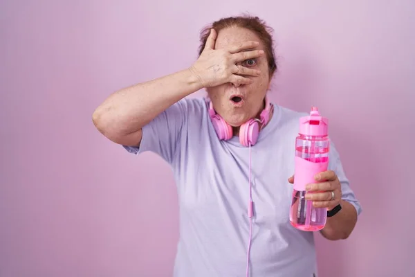 Senior Woman Wearing Sportswear Headphones Peeking Shock Covering Face Eyes — Stock Photo, Image