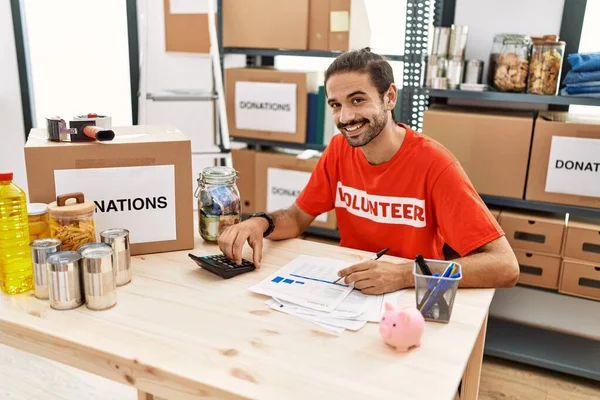 Handsome Hispanic Man Working Volunteer Calculating Donations Donation Stand — Zdjęcie stockowe