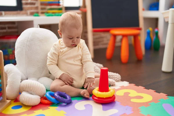 愛らしいCucasian赤ん坊遊びとともにフープおもちゃで床に座って幼稚園 — ストック写真