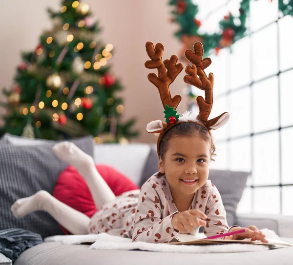 Adorable Hispanic Girl Smiling Confident Lying Sofa Christmas Tree Home — Stockfoto