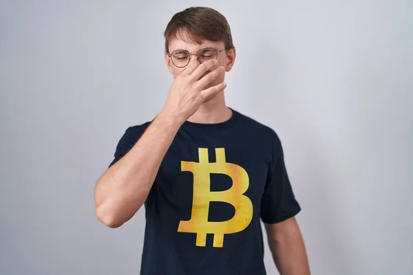 Caucasian Blond Man Wearing Bitcoin Shirt Smelling Something Stinky Disgusting — Foto Stock