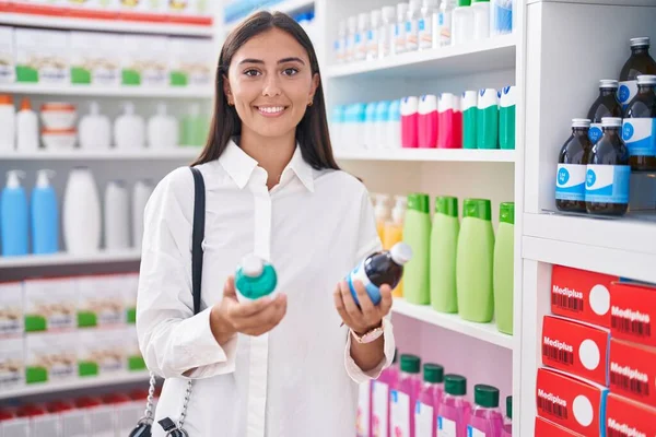 Young Beautiful Hispanic Woman Customer Smiling Confident Holding Medication Bottles — Stockfoto