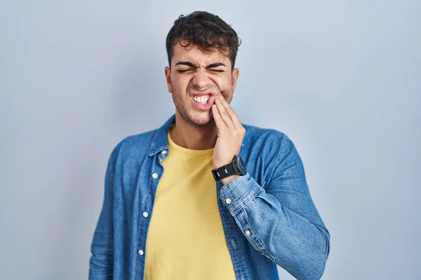 Young Hispanic Man Standing Blue Background Touching Mouth Hand Painful — Stok fotoğraf