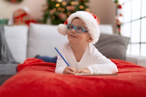 令人羡慕的是 他那惊慌失措的小孩躺在沙发上 在笔记本上写着圣诞老人的名字 — 图库照片