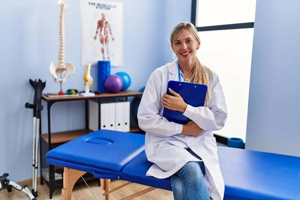 Young Blonde Woman Wearing Physiotherpist Uniform Holding Checklist Physiotherapy Clinic — Stockfoto