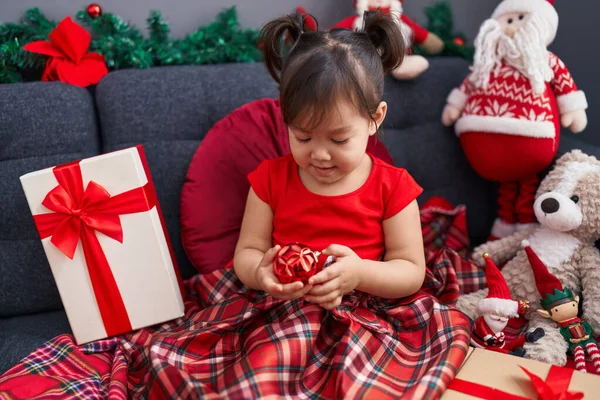 可爱的中国女孩坐在沙发上 坐在家里的圣诞装饰品旁 — 图库照片