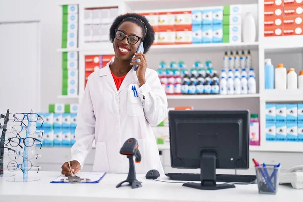 Africano Farmacêutico Mulher Americana Falando Smartphone Escrevendo Documento Farmácia — Fotografia de Stock