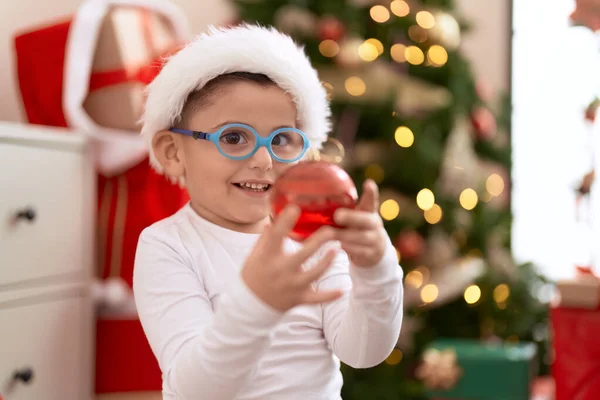 Adorable Niño Hispano Sonriendo Confiado Sosteniendo Bola Decoración Navidad Casa —  Fotos de Stock