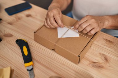 Middle age woman ecommerce business worker preparing package at office