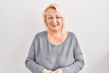 Middle age caucasian woman standing over white background with hands together and crossed fingers smiling relaxed and cheerful. success and optimistic 