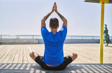 Ağaç pozu veren Latin kökenli genç adam.