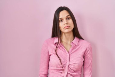 Pembe arka planda duran genç İspanyol kadın uykulu ve yorgun görünüyor, yorgunluktan yorgun ve akşamdan kalma, sabahları tembel gözler.. 