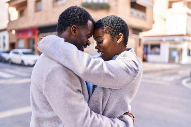 Man and woman couple hugging each other standing at street
