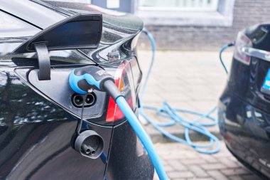 Elektrikli araba sokakta şarj oluyor.