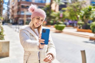 Young woman smiling confident making selfie by the smartphone at street