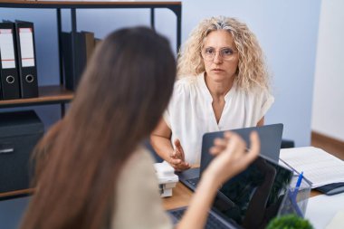 Two women business workers using laptop working at office