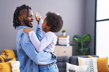 Father and daughter smiling confident dancing at home