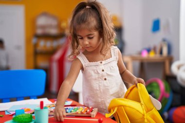 Anaokulunda sırt çantası taşıyan sevimli İspanyol kız anaokulu öğrencisi.