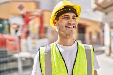 Genç İspanyol mimar parkta kendine güvenerek gülümsüyor.