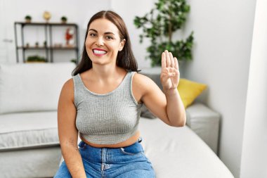 Genç ve güzel İspanyol kadın evdeki kanepede oturan sağırlarla iletişim kuruyor.