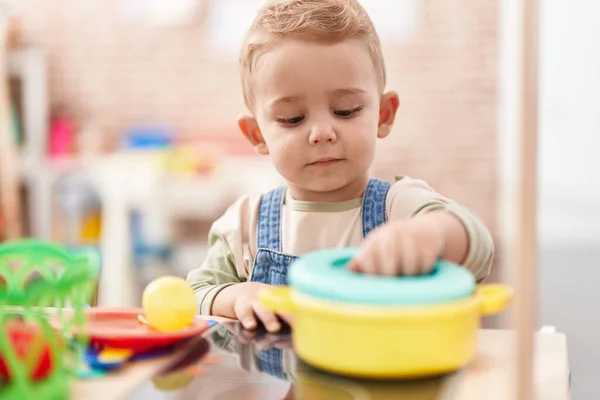 stock image Adorable toddler playing with play kitchen standing at kindergarten