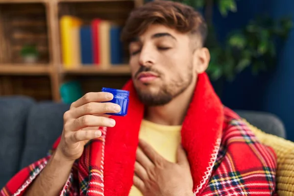 Young Arab Man Smelling Mint Medication Sitting Sofa Home — Photo