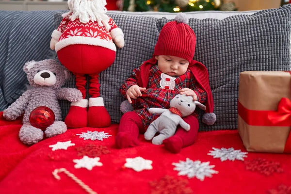 可爱的高加索宝宝抱着泰迪熊坐在家里圣诞树旁的沙发上 — 图库照片