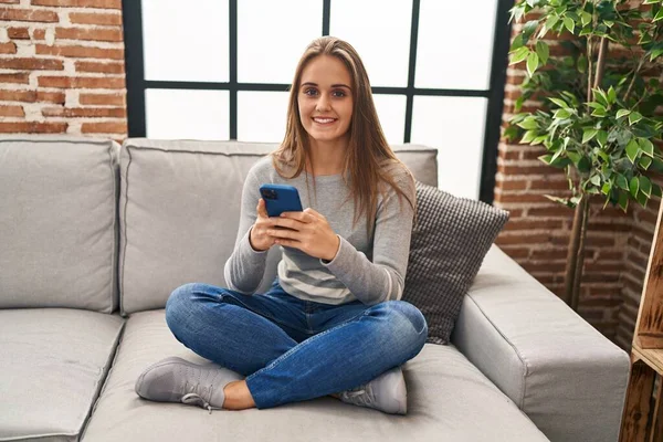 Jovem Loira Sorrindo Confiante Usando Smartphone Casa — Fotografia de Stock