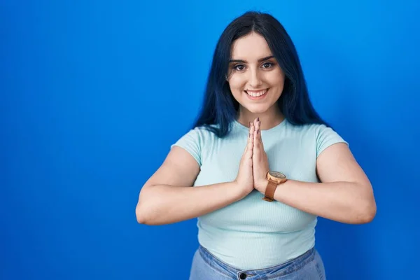 Young Modern Girl Blue Hair Standing Blue Background Praying Hands — Foto de Stock