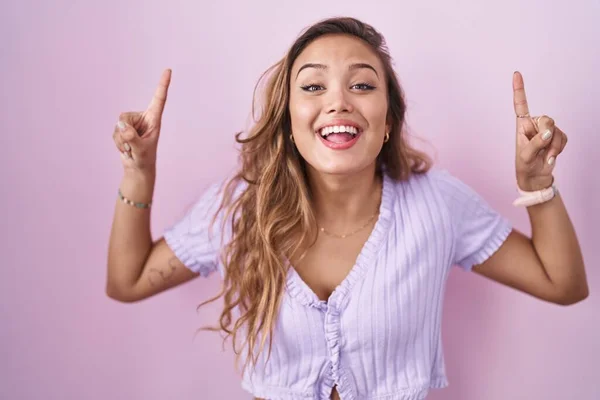 Young Hispanic Woman Standing Pink Background Smiling Amazed Surprised Pointing — Photo