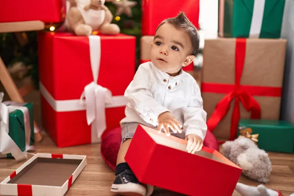 可敬的是 他那惊慌失措的小孩打开包装 坐在家里地板上的圣诞礼物 — 图库照片