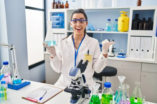 Hispanic Woman Working Scientist Laboratory Pointing Thumb Side Smiling Happy — Stock Photo, Image
