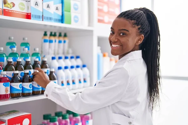 African American Woman Pharmacist Smiling Confident Organize Shelving Pharmacy — Stok fotoğraf