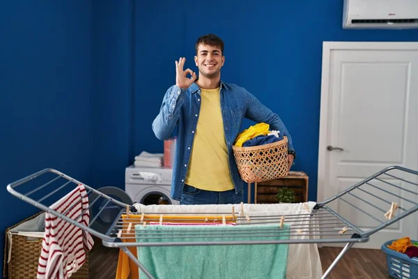 Young Hispanic Man Hanging Clothes Clothesline Doing Sign Fingers Smiling — Stock Photo, Image