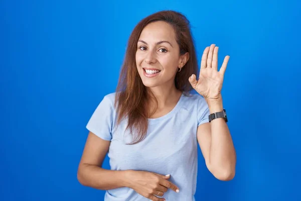 Brunette Woman Standing Blue Background Waiving Saying Hello Happy Smiling — Stok fotoğraf