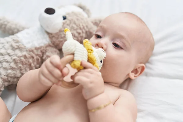 Liebenswertes Kaukasisches Baby Liegt Auf Bett Und Beißt Puppe Schlafzimmer — Stockfoto