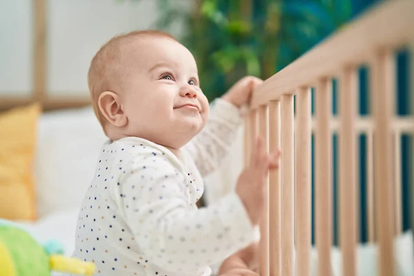 可爱的高加索婴儿微笑着自信地站在床上 — 图库照片
