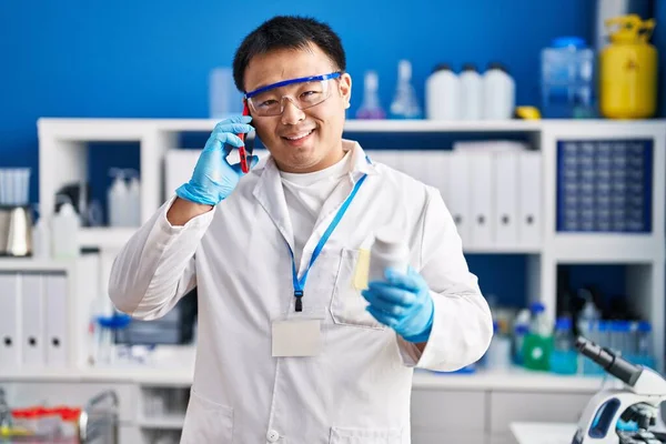 Young Chinese Man Wearing Scientist Uniform Using Smartphone Laboratory — Stockfoto