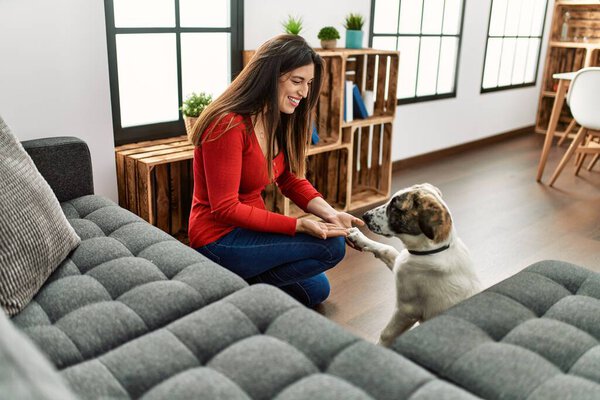 Young woman smiling confident teaching dog at home