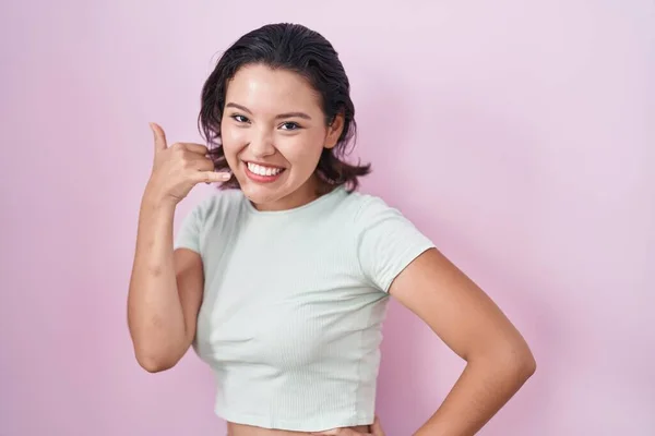 Hispanic Young Woman Standing Pink Background Smiling Doing Phone Gesture — 图库照片