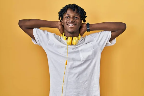 Young African Man Dreadlocks Standing Yellow Background Relaxing Stretching Arms — Stok fotoğraf