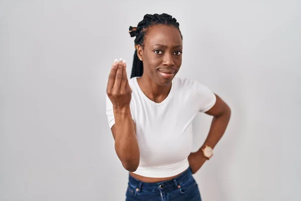 Beautiful black woman standing over isolated background doing italian gesture with hand and fingers confident expression