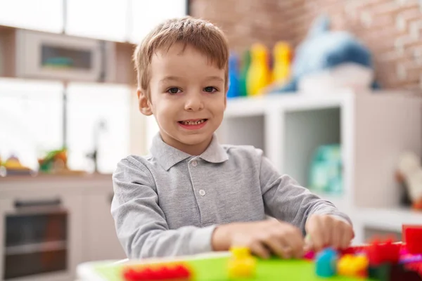 愛らしい幼児遊びます建設ブロックでテーブルの上に座って幼稚園 — ストック写真