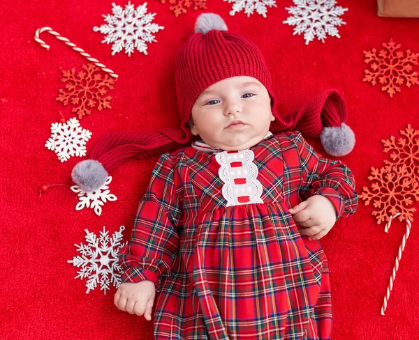 可爱的高加索婴儿躺在地板上 在孤立的红色背景上装饰着圣诞节 — 图库照片