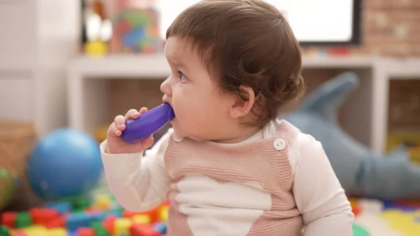 Liebenswertes Kleinkind Beißt Plastikspielzeug Kindergarten Auf Dem Boden — Stockfoto
