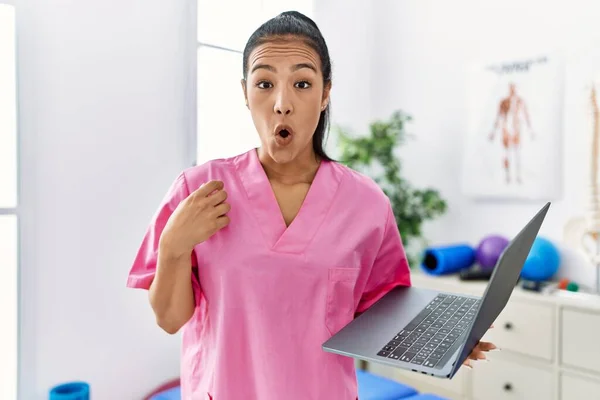 Young Hispanic Physiotherapist Woman Using Computer Laptop Medical Clinic Scared — Stockfoto